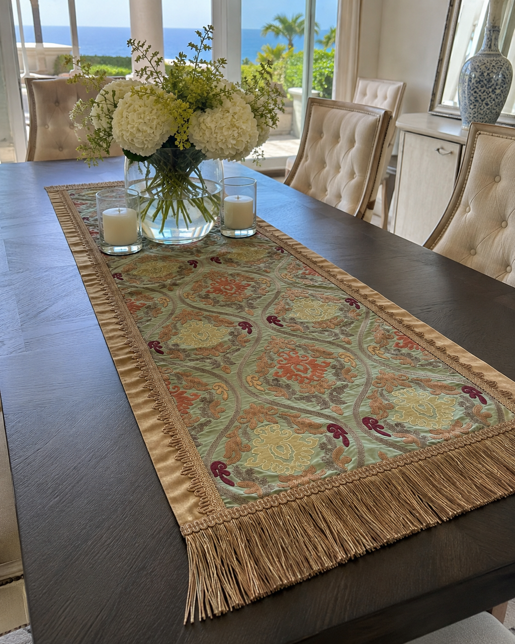 Sage green damask table runner styled on a dark wood dining table with candles and white hydrangeas