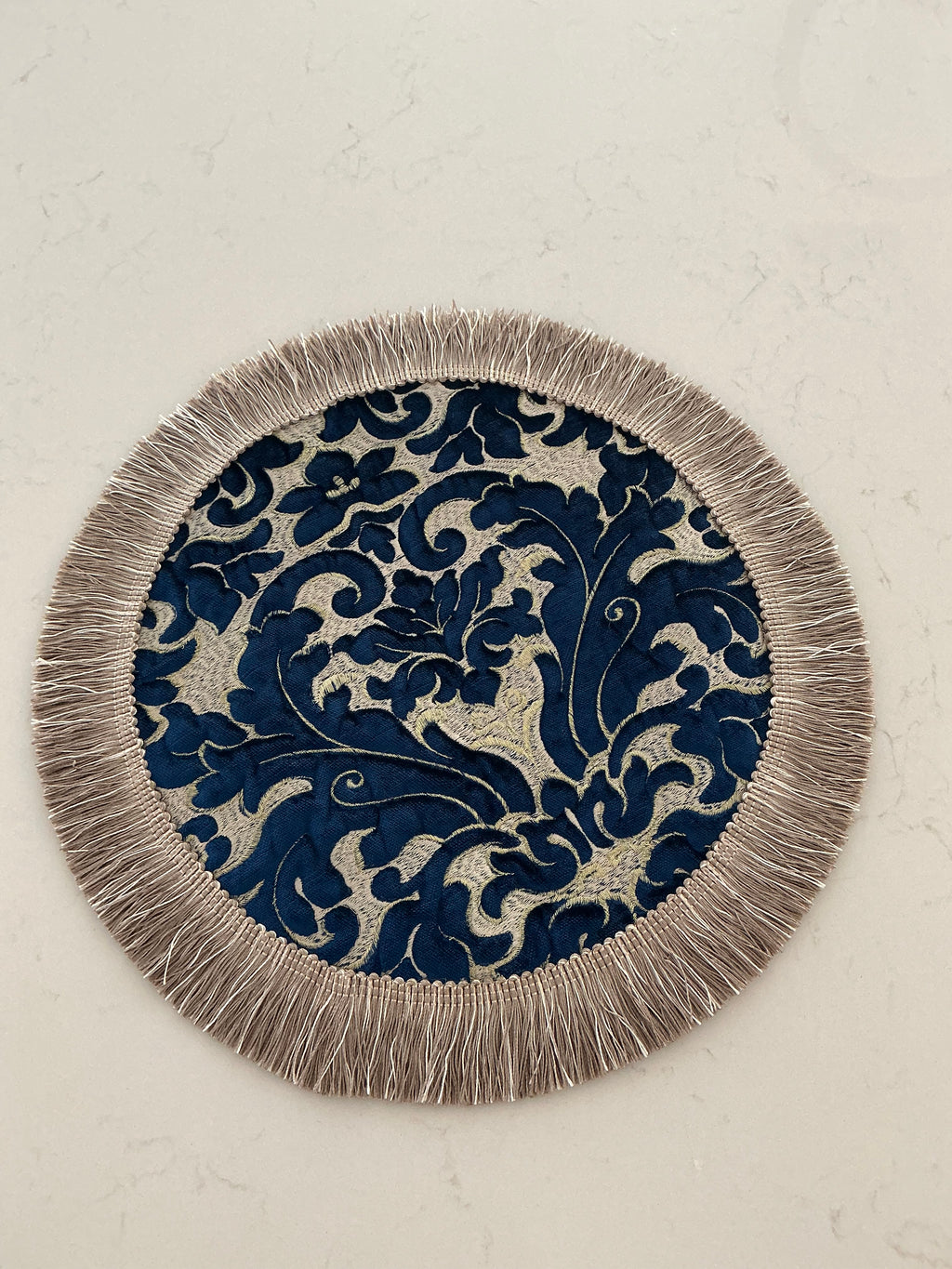 Two ornate navy and silver round table toppers displayed side by side