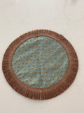 Ornate round table topper in sage green and copper jacquard with scattered leaf motif and tassel fringe border