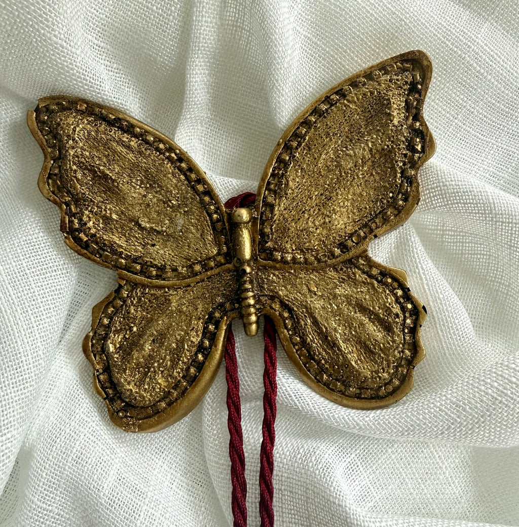 Scalloped gold oval frame with floral tapestry insert and burgundy tassel