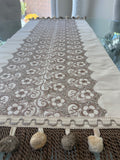 Floral lace table runner close-up showing pom pom tassel fringe detail