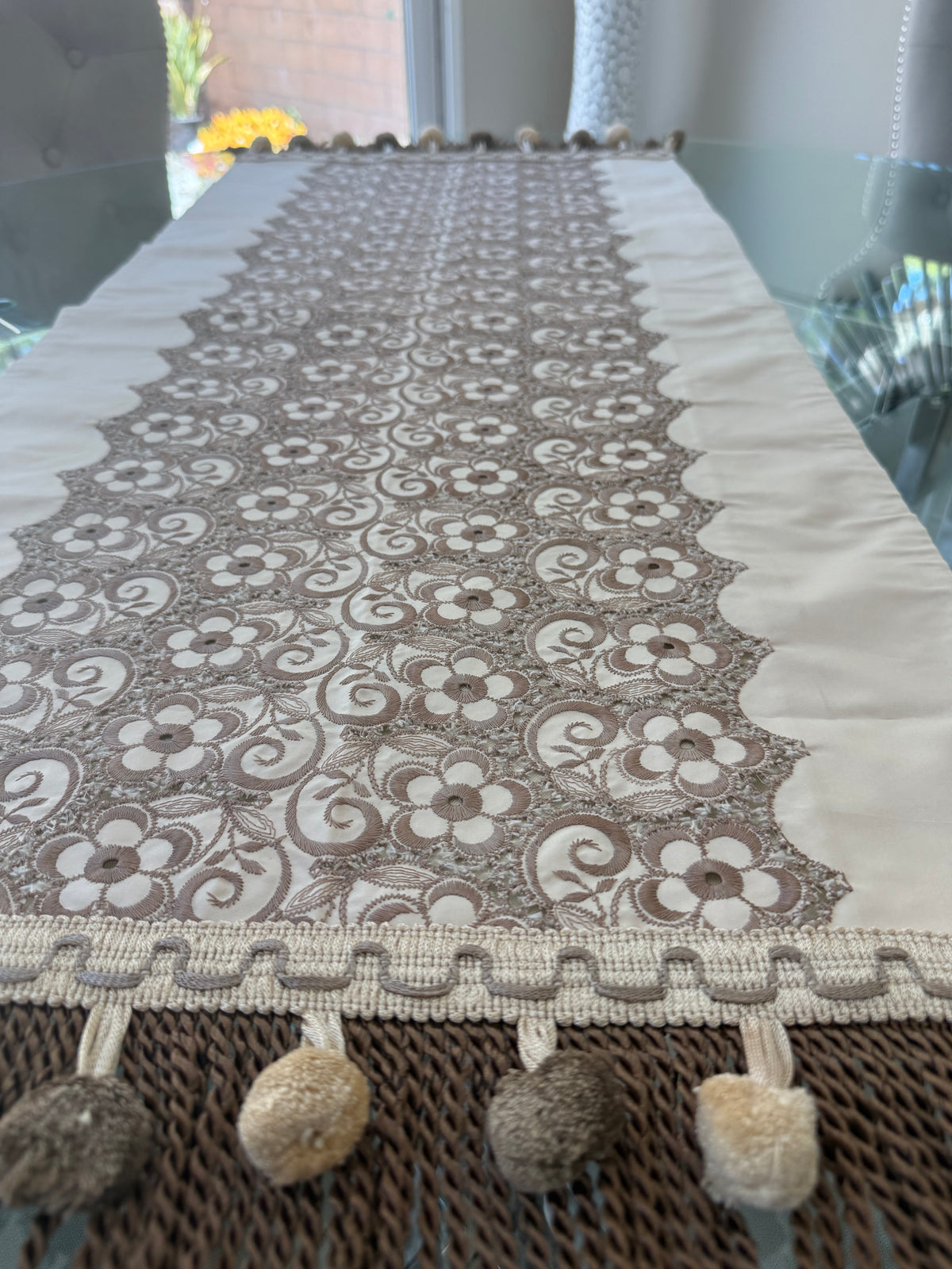 Floral lace table runner close-up showing pom pom tassel fringe detail