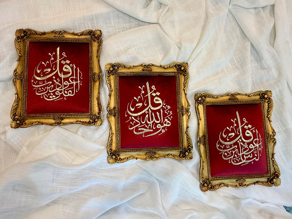 Close-up of ornate antique gold frame and gold Arabic calligraphy on burgundy background